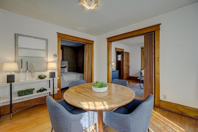 dining area featuring light wood-type flooring and baseboards