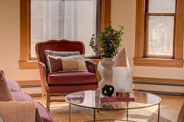 living area featuring a baseboard heating unit and wood finished floors