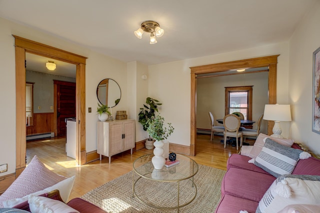 living area with light wood-type flooring and a baseboard heating unit