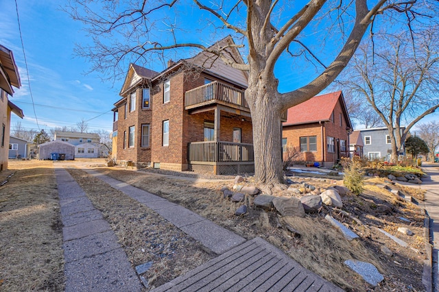 view of front of home featuring brick siding, a residential view, and a balcony