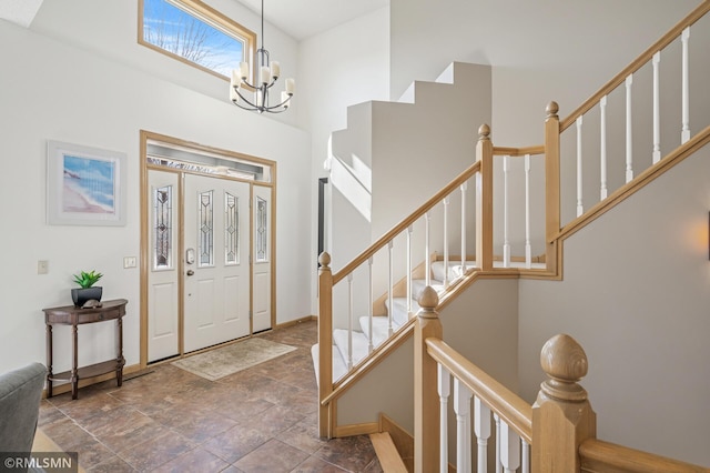 entryway featuring a notable chandelier, stairway, a high ceiling, and baseboards