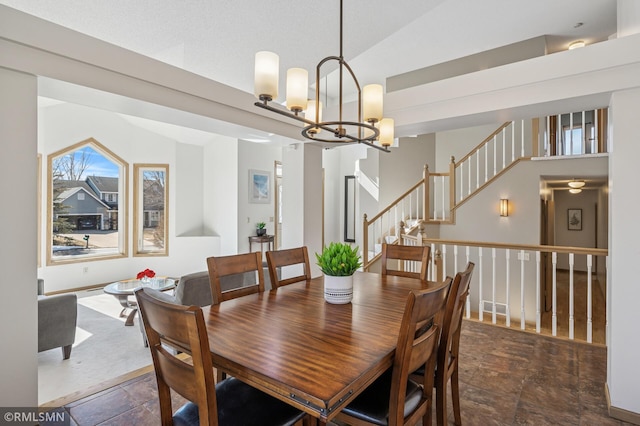 dining room with vaulted ceiling, stone finish flooring, and a chandelier