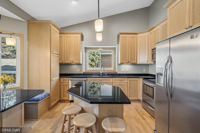 kitchen with light wood-style flooring, a sink, light brown cabinetry, vaulted ceiling, and stainless steel appliances