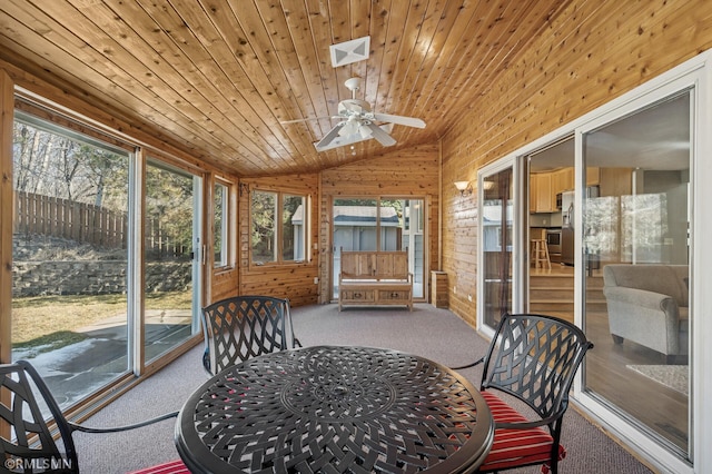 sunroom featuring a healthy amount of sunlight, wood ceiling, ceiling fan, and vaulted ceiling