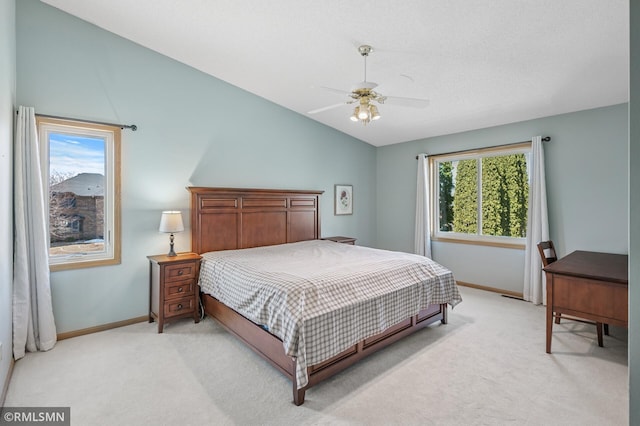 bedroom featuring light carpet, a ceiling fan, baseboards, and vaulted ceiling