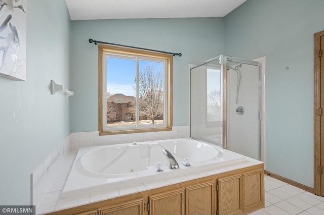 bathroom featuring tile patterned floors, a tub with jets, and a stall shower