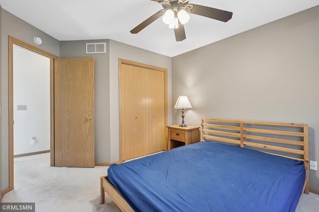 carpeted bedroom with visible vents, baseboards, a closet, and a ceiling fan