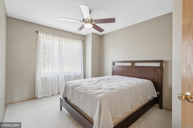 bedroom featuring baseboards, carpet, a ceiling fan, and a textured ceiling