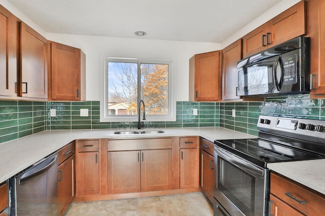 kitchen featuring brown cabinets, tasteful backsplash, appliances with stainless steel finishes, and a sink