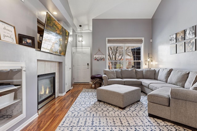 living area with wood finished floors, a fireplace, and baseboards