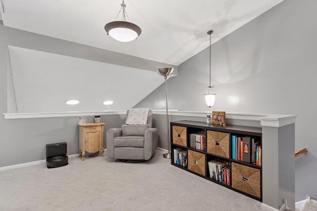 living area featuring vaulted ceiling, an upstairs landing, baseboards, and carpet floors