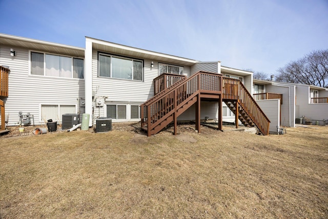 back of house featuring stairway, a lawn, central AC, and a wooden deck