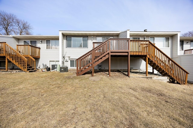 back of property with stairway, cooling unit, a yard, and a deck