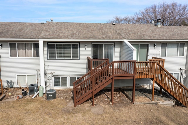 back of property featuring stairs, central AC unit, and roof with shingles