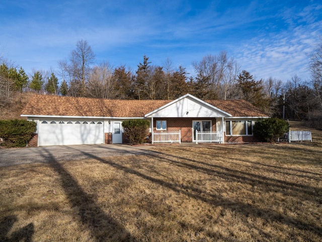 view of front of property with a front yard, brick siding, covered porch, and driveway