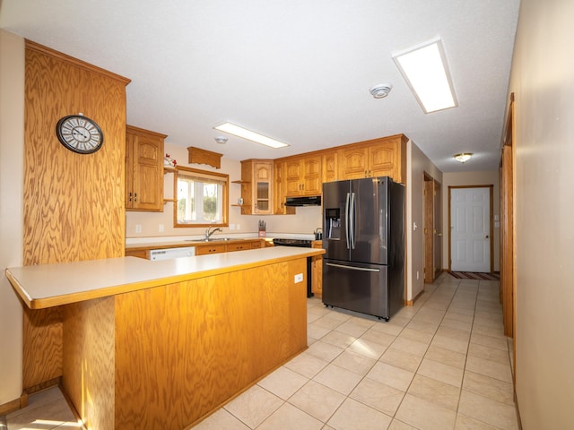 kitchen with light countertops, a peninsula, stainless steel refrigerator with ice dispenser, white dishwasher, and a sink