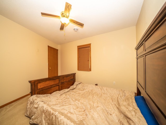 bedroom with light colored carpet, baseboards, and ceiling fan