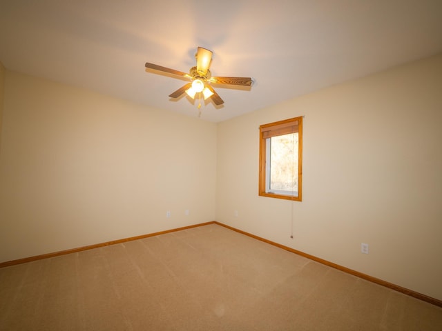 empty room featuring light carpet, ceiling fan, and baseboards