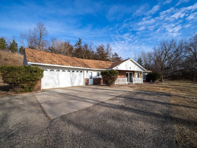 view of front facade featuring a porch, driveway, and a garage