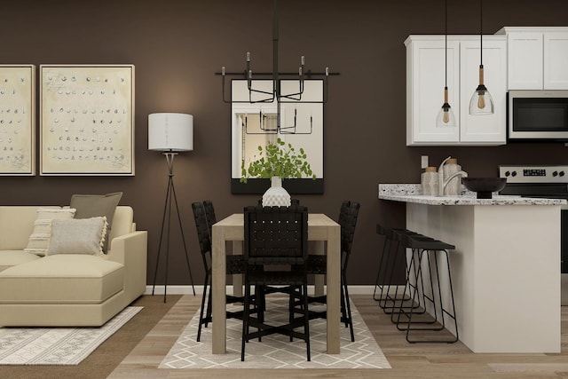 dining room featuring baseboards and light wood-style floors