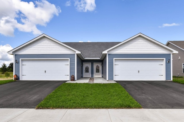 single story home featuring aphalt driveway, an attached garage, a front lawn, and a shingled roof