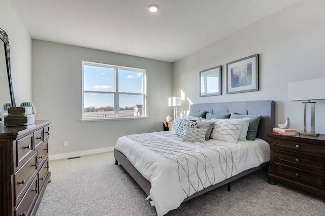 bedroom with visible vents, multiple windows, light colored carpet, and baseboards