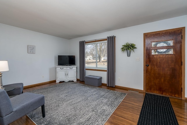 living room featuring baseboards and dark wood-style floors