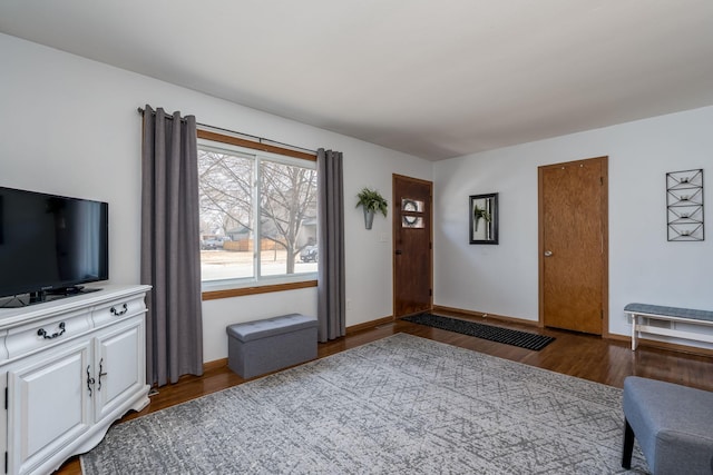 unfurnished living room with wood finished floors and baseboards