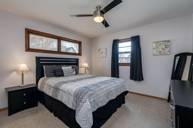 bedroom with a ceiling fan, baseboards, and light carpet