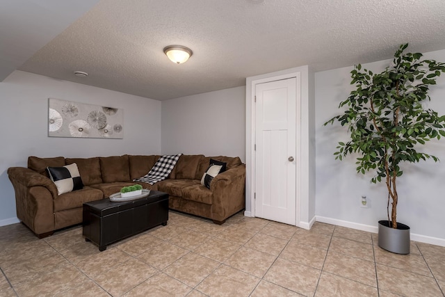 living room featuring light tile patterned floors, baseboards, and a textured ceiling