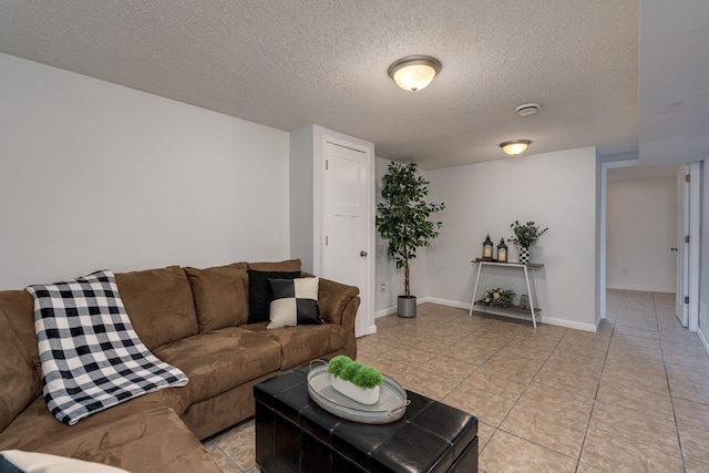 living area featuring light tile patterned floors, a textured ceiling, and baseboards