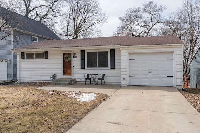 view of front of house featuring an attached garage, driveway, and a shingled roof