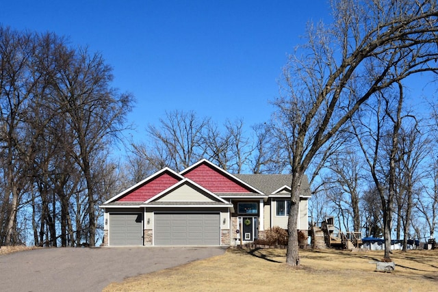 craftsman-style home with a garage, stone siding, and aphalt driveway