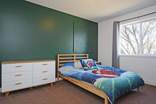 bedroom featuring dark carpet and a textured ceiling