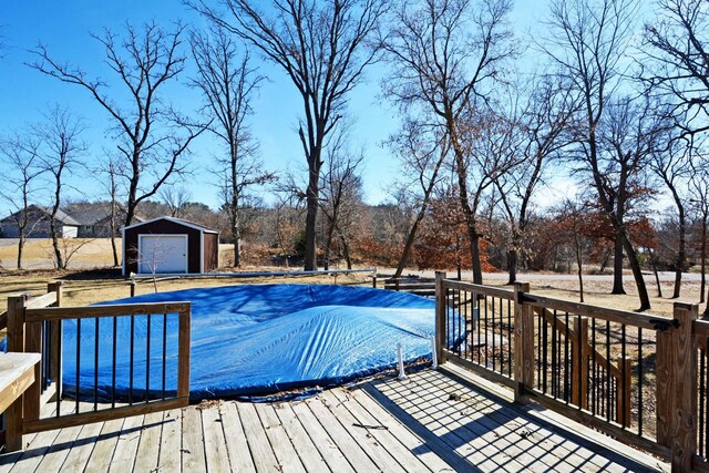 view of pool featuring a covered pool, an outdoor structure, and a deck