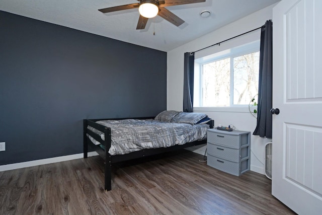 bedroom featuring baseboards, dark wood-style floors, and a ceiling fan