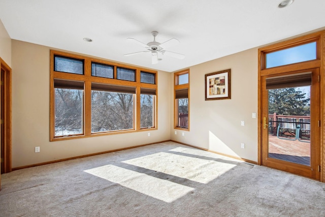 spare room with baseboards, ceiling fan, and carpet flooring