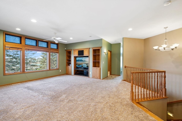 unfurnished living room featuring recessed lighting, baseboards, carpet, and ceiling fan with notable chandelier