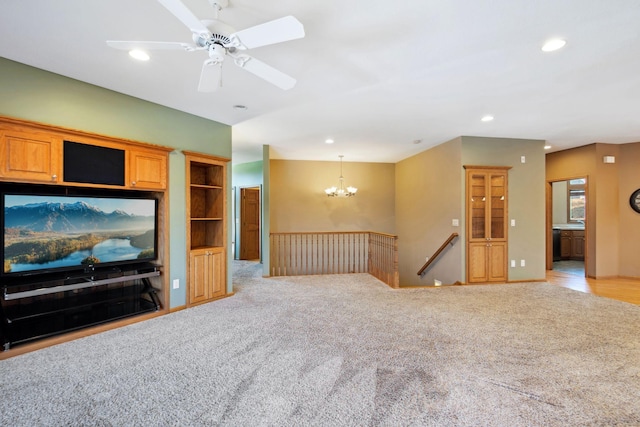 carpeted living room featuring recessed lighting and ceiling fan with notable chandelier