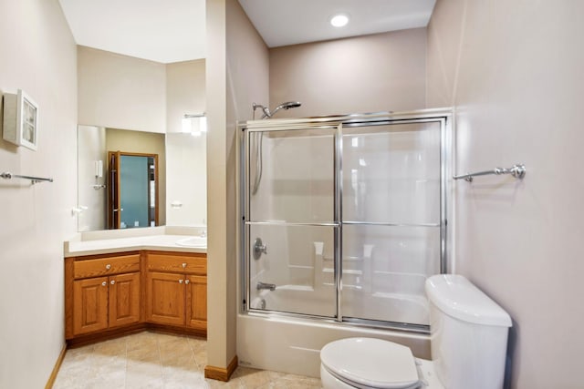 bathroom with tile patterned floors, toilet, shower / bath combination with glass door, baseboards, and vanity