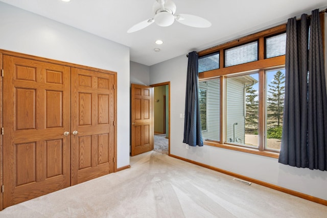 unfurnished bedroom with visible vents, light carpet, baseboards, and a closet