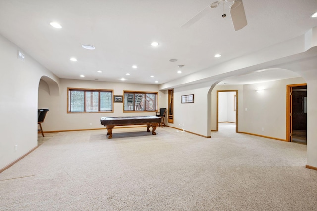 playroom with light colored carpet, arched walkways, and baseboards