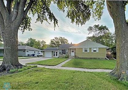 single story home featuring a front lawn and a garage