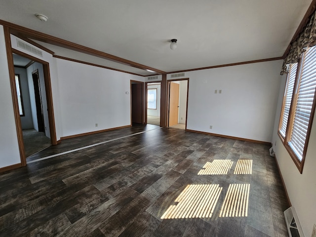 unfurnished room featuring visible vents, wood finished floors, and ornamental molding