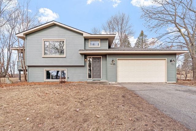 split level home with an attached garage and driveway