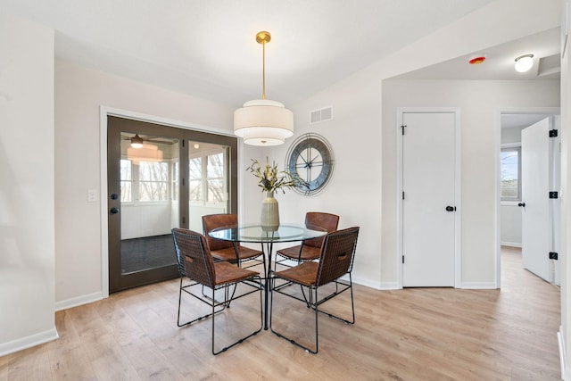 dining area featuring visible vents, light wood-style flooring, and baseboards