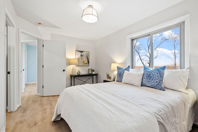 bedroom with light wood finished floors and baseboards