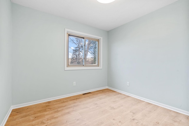 unfurnished room featuring visible vents, baseboards, and light wood-style floors