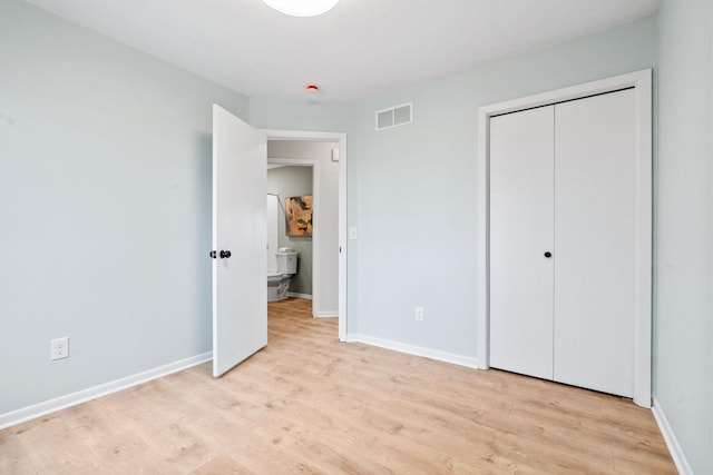 unfurnished bedroom featuring light wood-style flooring, baseboards, visible vents, and a closet