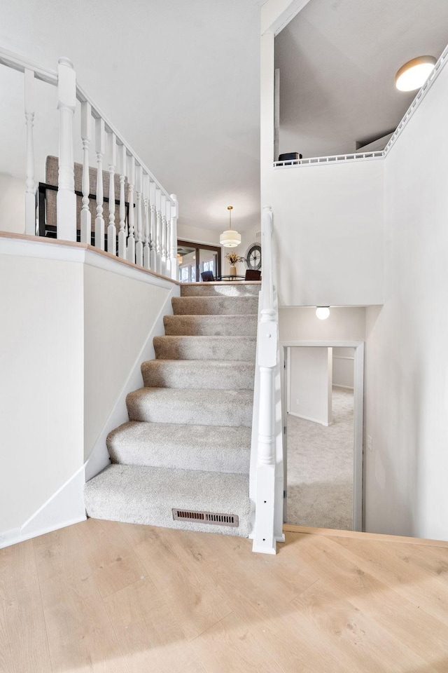 staircase with visible vents and wood finished floors